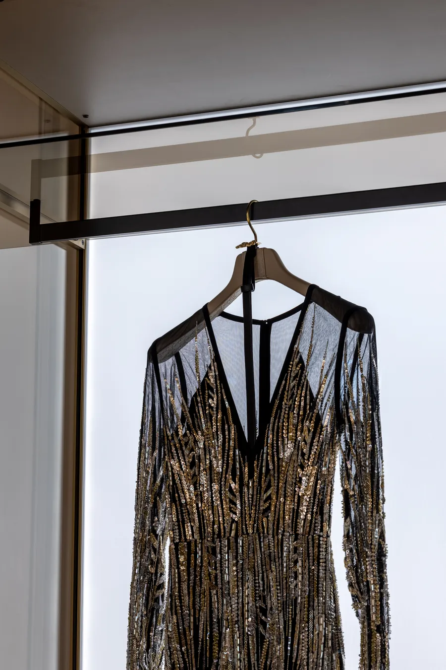Evening dress hanging inside an ELIE SAAB Maison glass wardrobe