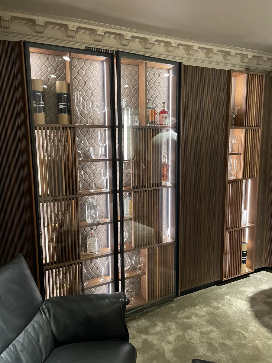 Swing Bookcase with glass doors, quilted back panels and fluted walnut shutters