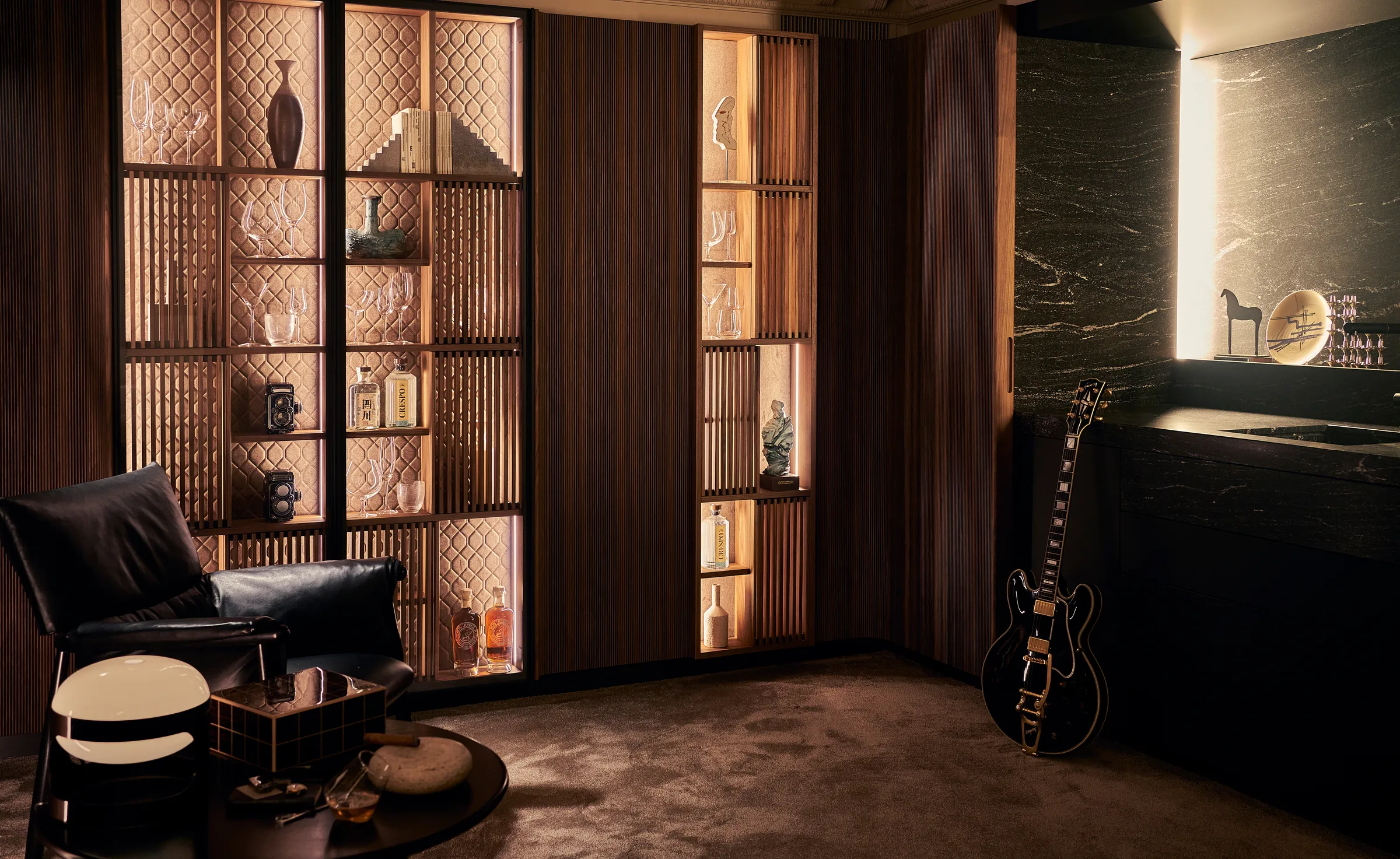 Swing Bookcase in walnut with lit display shelves, beside a stone bar